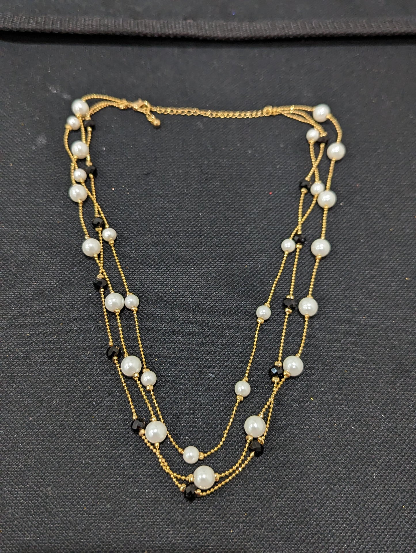 Triple stranded pearl and black bead necklace