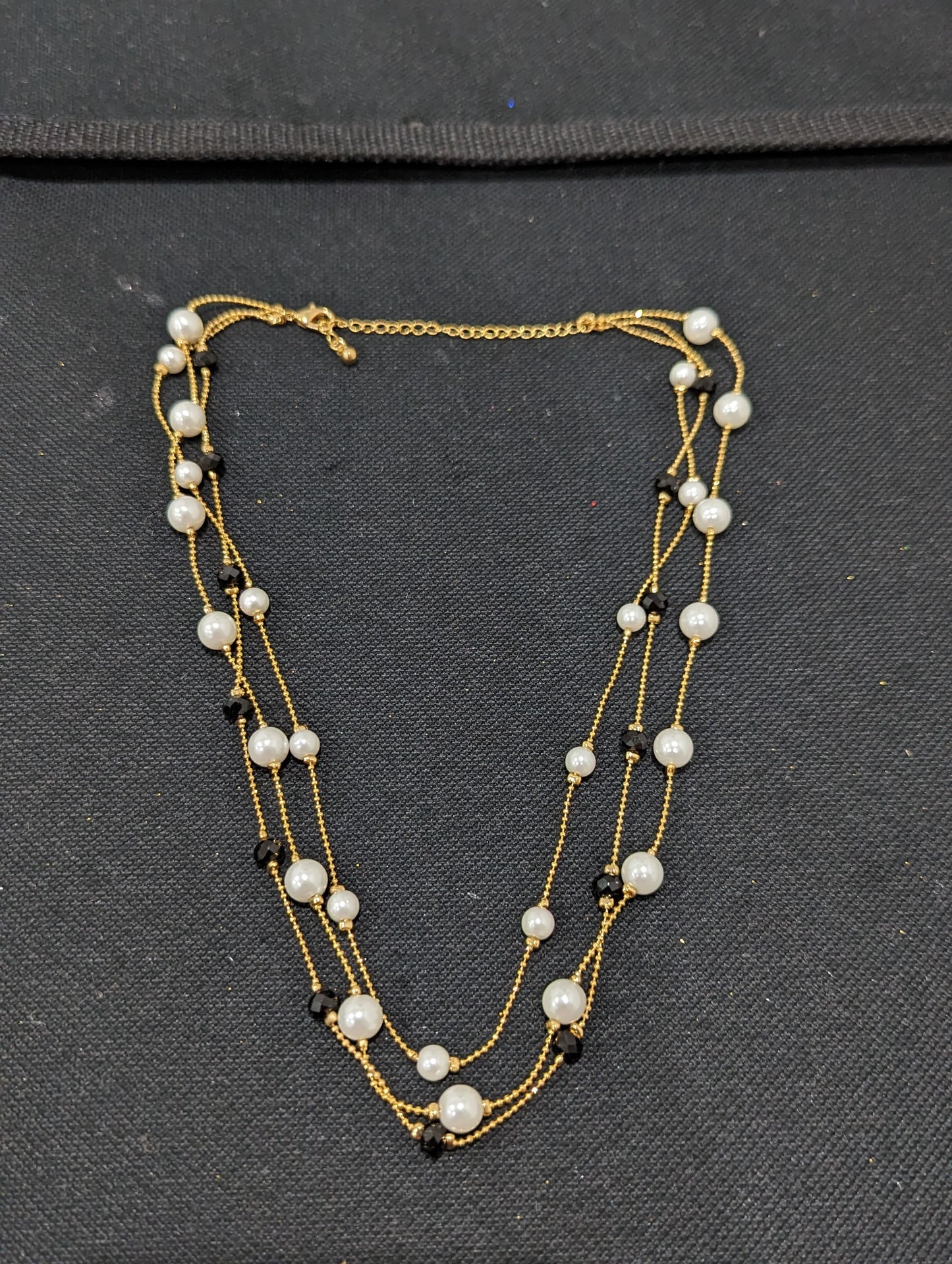 Triple stranded pearl and black bead necklace